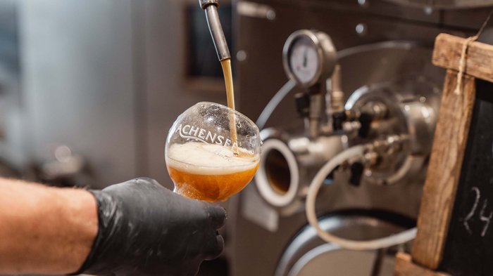 The Karlwirt’s Achenseebier Beer being poured from a tap into an Achensee beer glass