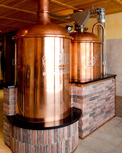 Das Hotel Karlwirt: herzlich willkommen! Kupferne Bierbrauanlage in einem Raum mit Holzdach und Steinverkleidung